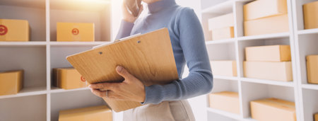 Startup SME small business entrepreneur of freelance Asian woman wearing apron using laptop and box...