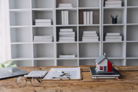 Real estate broker agent presenting and consult to customer to decision making sign insurance form agreement, buy and sell home model, concerning mortgage loan offer for and house insuranceの写真素材