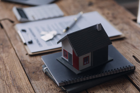 Real estate broker agent presenting and consult to customer to decision making sign insurance form agreement, buy and sell home model, concerning mortgage loan offer for and house insuranceの写真素材