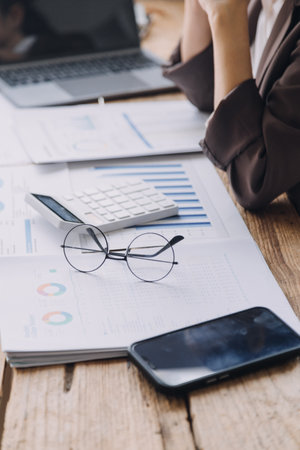 Businesswoman or accountant working Financial investment on calculator, calculate, analyze business and marketing growth on financial document data graph, Accounting, Economic, commercial concept.の写真素材