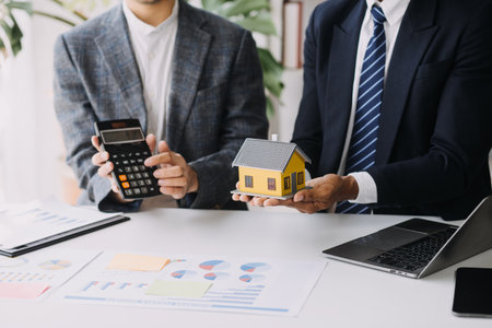 Real estate broker agent presenting and consult to customer to decision making sign insurance form agreement, buy and sell home model, concerning mortgage loan offer for and house insurance