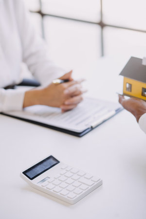 House model with real estate agent and customer discussing for contract to buy house, insurance or loan real estate background.の写真素材