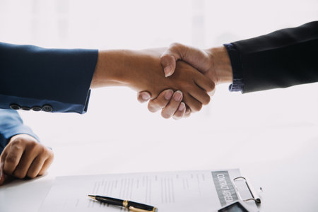 A car rental company employee is handing out the car keys to the renter after discussing the rental...