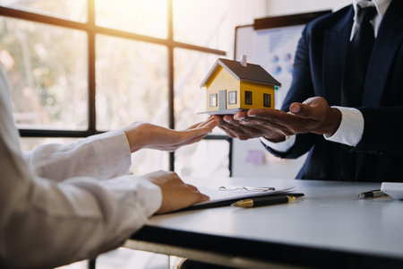 House model with real estate agent and customer discussing for contract to buy house, insurance or loan real estate background.の写真素材