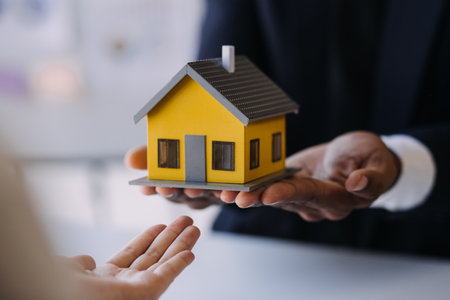 House model with real estate agent and customer discussing for contract to buy house, insurance or loan real estate background.の写真素材