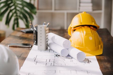 Image of engineering objects on workplace with three partners interacting on background