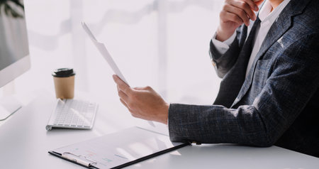 Financial analysts analyze business financial reports on a digital tablet planning investment project during a discussion at a meeting of corporate showing the results of their successful teamwork.の写真素材