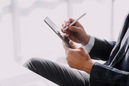 Financial analysts analyze business financial reports on a digital tablet planning investment project during a discussion at a meeting of corporate showing the results of their successful teamwork.の写真素材