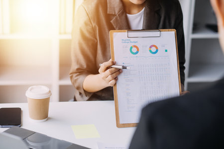 Financial analysts analyze business financial reports on a digital tablet planning investment project during a discussion at a meeting of corporate showing the results of their successful teamwork.の写真素材