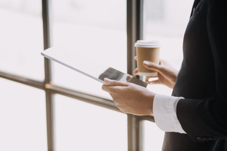 Financial analysts analyze business financial reports on a digital tablet planning investment project during a discussion at a meeting of corporate showing the results of their successful teamwork.の写真素材