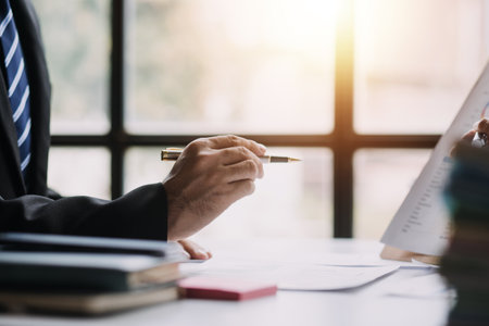 Financial analysts analyze business financial reports on a digital tablet planning investment project during a discussion at a meeting of corporate showing the results of their successful teamwork.の写真素材