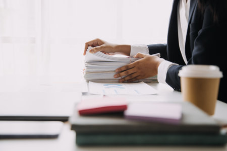 Financial analysts analyze business financial reports on a digital tablet planning investment project during a discussion at a meeting of corporate showing the results of their successful teamwork.の写真素材