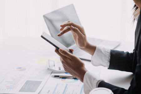 Financial analysts analyze business financial reports on a digital tablet planning investment project during a discussion at a meeting of corporate showing the results of their successful teamwork.の写真素材