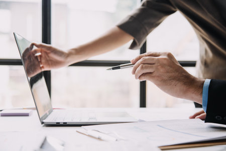 Financial analysts analyze business financial reports on a digital tablet planning investment project during a discussion at a meeting of corporate showing the results of their successful teamwork.の写真素材