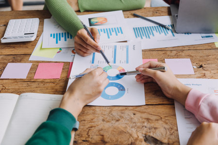 Financial analysts analyze business financial reports on a digital tablet planning investment project during a discussion at a meeting of corporate showing the results of their successful teamwork.の写真素材