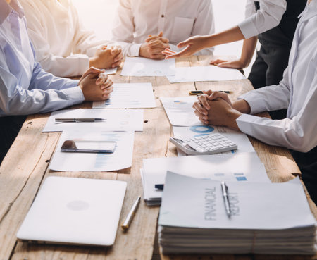 Financial analysts analyze business financial reports on a digital tablet planning investment project during a discussion at a meeting of corporate showing the results of their successful teamwork.の写真素材