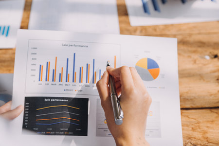 Financial analysts analyze business financial reports on a digital tablet planning investment project during a discussion at a meeting of corporate showing the results of their successful teamwork.の写真素材