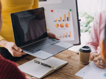 Financial analysts analyze business financial reports on a digital tablet planning investment project during a discussion at a meeting of corporate showing the results of their successful teamwork.の写真素材