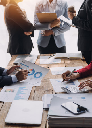 Financial analysts analyze business financial reports on a digital tablet planning investment project during a discussion at a meeting of corporate showing the results of their successful teamwork.の写真素材