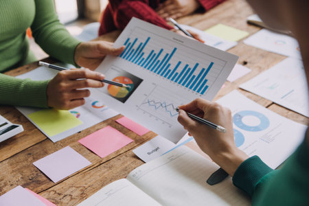 Financial analysts analyze business financial reports on a digital tablet planning investment project during a discussion at a meeting of corporate showing the results of their successful teamwork.の写真素材