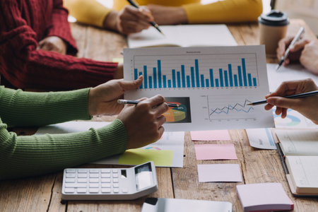 Financial analysts analyze business financial reports on a digital tablet planning investment project during a discussion at a meeting of corporate showing the results of their successful teamwork.の写真素材