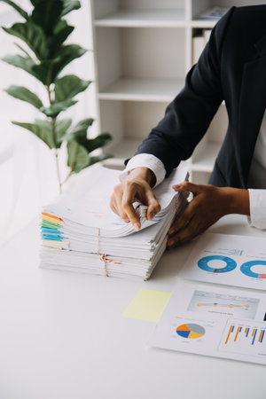 Financial analysts analyze business financial reports on a digital tablet planning investment project during a discussion at a meeting of corporate showing the results of their successful teamwork.の写真素材