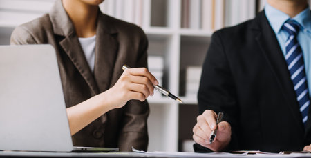 Financial analysts analyze business financial reports on a digital tablet planning investment project during a discussion at a meeting of corporate showing the results of their successful teamwork.の写真素材