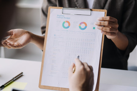 Financial analysts analyze business financial reports on a digital tablet planning investment...
