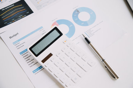Financial analysts analyze business financial reports on a digital tablet planning investment project during a discussion at a meeting of corporate showing the results of their successful teamwork.の写真素材