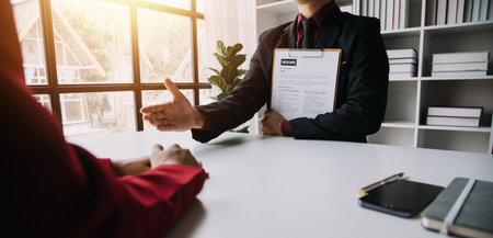 Close up view of job interview in office, focus on resume writing tips, employer reviewing good cv of prepared skilled applicant, recruiter considering application, hr manager making hiring decisionの写真素材