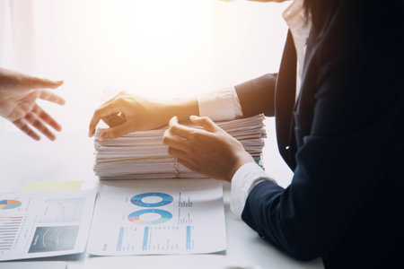 Financial analysts analyze business financial reports on a digital tablet planning investment project during a discussion at a meeting of corporate showing the results of their successful teamwork.の写真素材