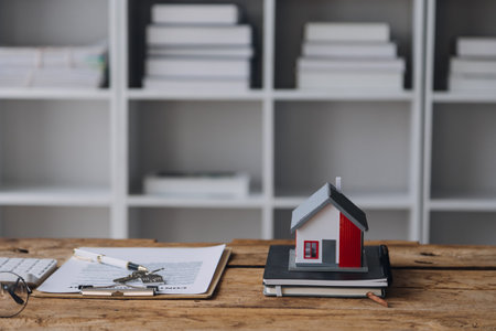 Real estate broker agent presenting and consult to customer to decision making sign insurance form agreement, buy and sell home model, concerning mortgage loan offer for and house insuranceの写真素材