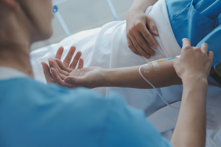 Women Asian doctors hold the patient hand and encourage and provide medical advice While checking the patient health in bed. Concept of Care and compassion, antenatal care, Threatened abortionの写真素材