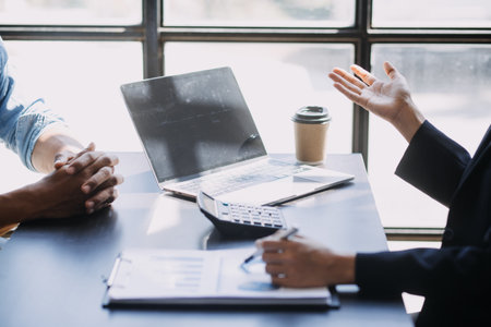 Asian Business woman using calculator and laptop for doing math finance on an office desk, tax, report, accounting, statistics, and analytical research conceptの写真素材