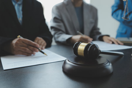 Judge gavel with Justice lawyers having team meeting at law firm in background. Concepts of law.の写真素材