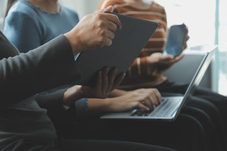 Beautiful woman sitting on a outdoors and using at laptop. Woman and friend having fun with new technology and shopping online at outdoor place.の写真素材