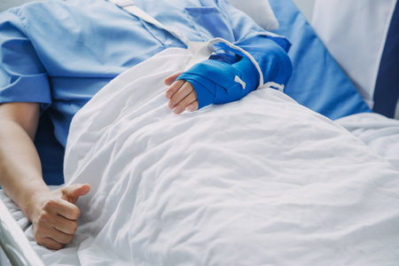 Injured patient showing doctor broken wrist and arm with bandage in hospital office or emergency room. Sprain, stress fracture or repetitive strain injury in hand. Nurse helping customer. First aid.の写真素材