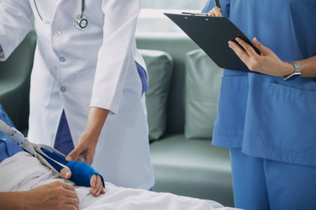 Injured patient showing doctor broken wrist and arm with bandage in hospital office or emergency room. Sprain, stress fracture or repetitive strain injury in hand. Nurse helping customer. First aid.の写真素材