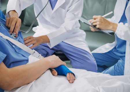 Injured patient showing doctor broken wrist and arm with bandage in hospital office or emergency room. Sprain, stress fracture or repetitive strain injury in hand. Nurse helping customer. First aid.の写真素材