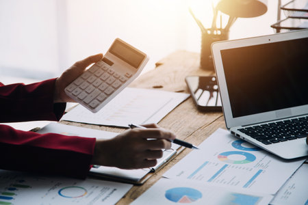 Businesswoman or accountant working Financial investment on calculator, calculate, analyze business and marketing growth on financial document data graph, Accounting, Economic, commercial concept.の写真素材
