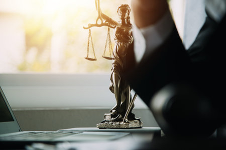 Business and lawyers discussing contract papers with brass scale on desk in office. Law, legal services, advice, justice and law concept picture with film grain effectの写真素材