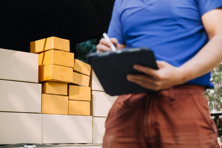Startup small business entrepreneur of freelance Asian woman using a laptop with box Cheerful success Asian woman her hand lifts up online marketing packaging box and delivery SME idea conceptの写真素材