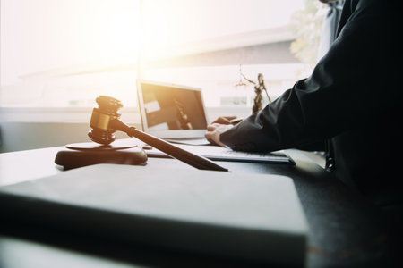 Business and lawyers discussing contract papers with brass scale on desk in office. Law, legal services, advice, justice and law concept picture with film grain effectの写真素材
