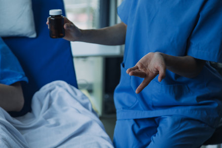 Side view of diverse doctors examining Asian female patient in bed in ward at hospital.の写真素材