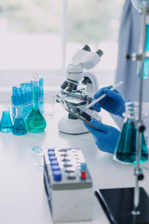 biochemical research scientist team working with microscope for coronavirus vaccine development in pharmaceutical research labolatory, selective focusの写真素材