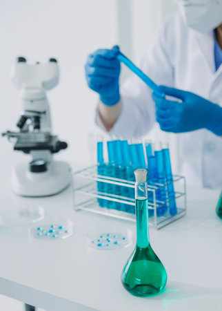 biochemical research scientist team working with microscope for coronavirus vaccine development in pharmaceutical research labolatory, selective focusの写真素材