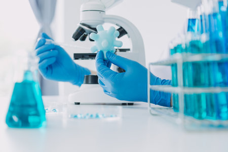 biochemical research scientist team working with microscope for coronavirus vaccine development in pharmaceutical research labolatory, selective focusの写真素材