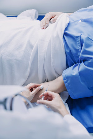 Side view of diverse doctors examining Asian female patient in bed in ward at hospital.の写真素材