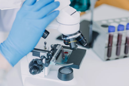 biochemical research scientist team working with microscope for coronavirus vaccine development in pharmaceutical research labolatory, selective focusの写真素材