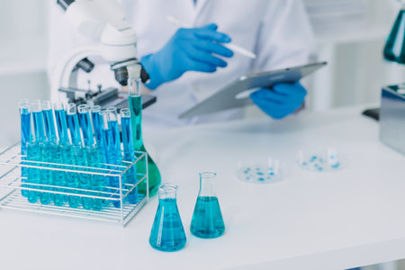 biochemical research scientist team working with microscope for coronavirus vaccine development in pharmaceutical research labolatory, selective focusの写真素材